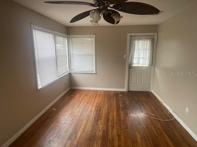 unfurnished room with ceiling fan and dark hardwood / wood-style flooring