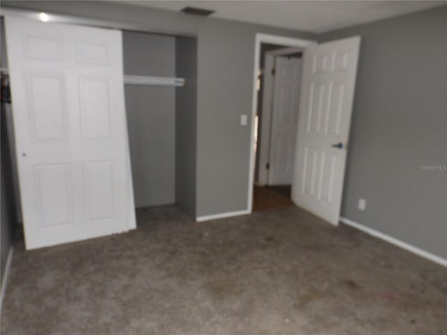 unfurnished bedroom with a closet, carpet flooring, visible vents, and baseboards