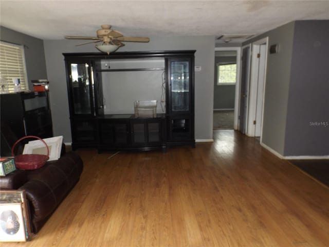 living area with ceiling fan, baseboards, and wood finished floors