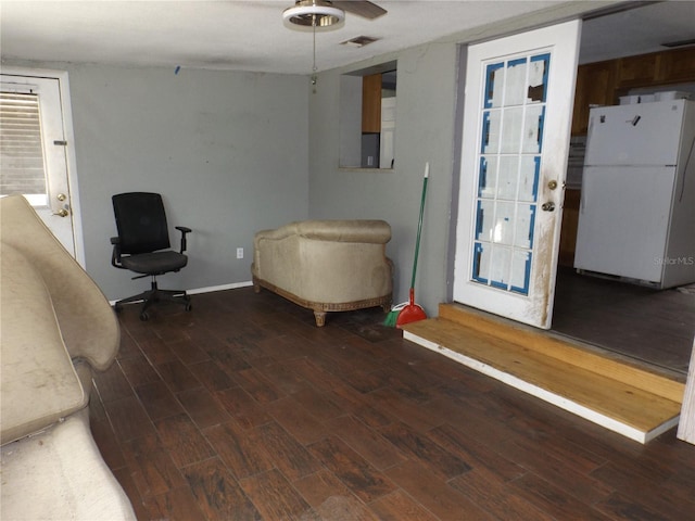 sitting room with dark wood finished floors, visible vents, and baseboards