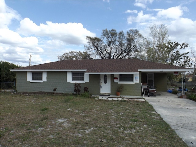 single story home featuring a front yard, brick siding, and roof with shingles