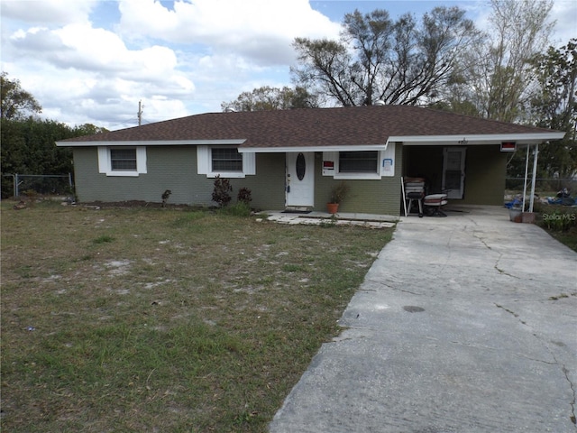 ranch-style home with driveway, brick siding, roof with shingles, and a front yard