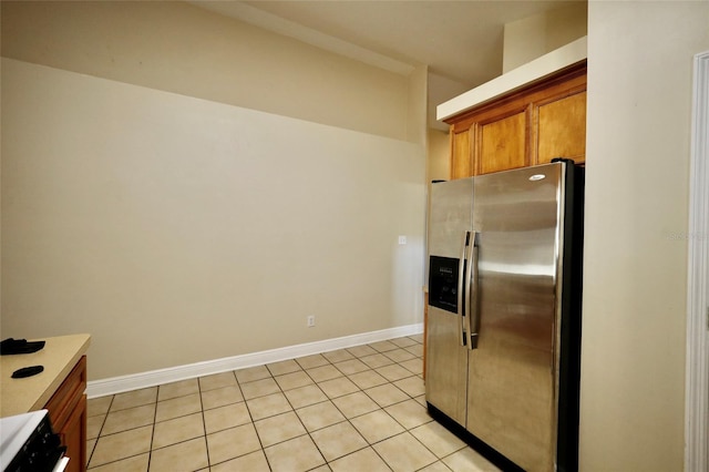 kitchen featuring light tile patterned floors and stainless steel refrigerator with ice dispenser