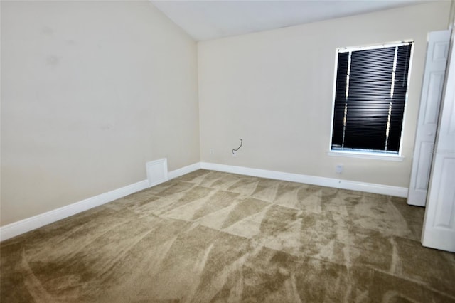 carpeted spare room with lofted ceiling