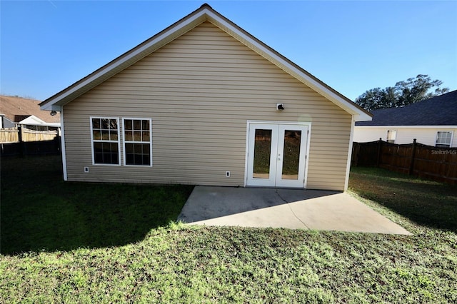 rear view of house featuring a patio, french doors, and a lawn