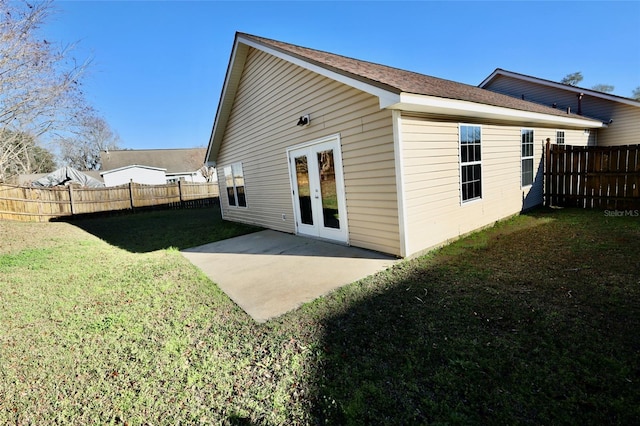 back of house featuring french doors, a lawn, and a patio area