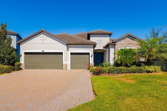 view of front of property with a garage and a front lawn