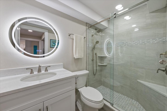 full bathroom with vanity, a shower stall, and toilet