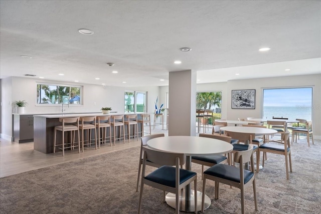 dining room with recessed lighting, light carpet, and a textured ceiling