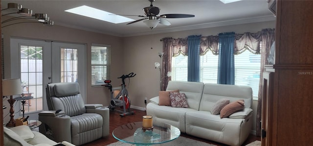 living room with hardwood / wood-style flooring, a skylight, ornamental molding, and french doors