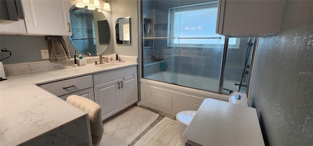 full bathroom with vanity, toilet, and combined bath / shower with glass door