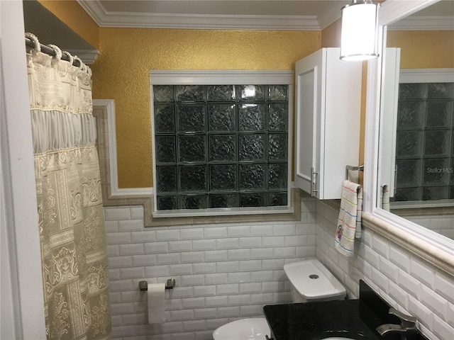 bathroom featuring tile walls, crown molding, and toilet