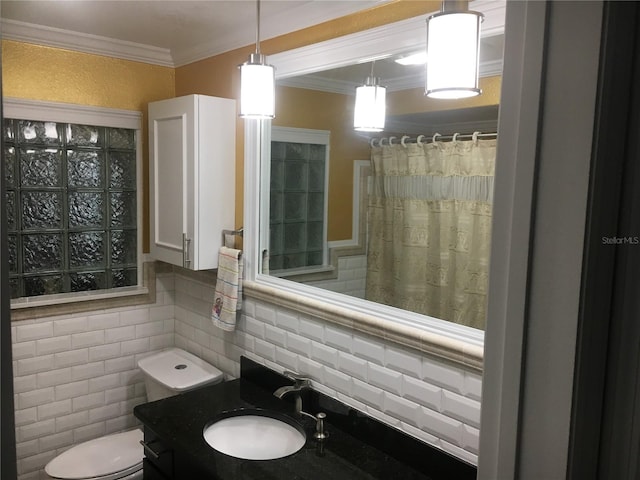 bathroom with crown molding, tile walls, vanity, and toilet