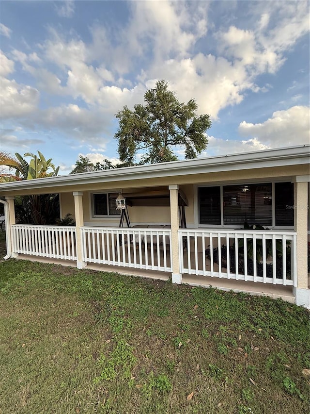 view of side of property featuring a porch and a yard