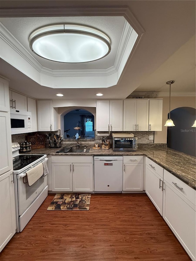 kitchen featuring a sink, white cabinetry, white appliances, crown molding, and a raised ceiling