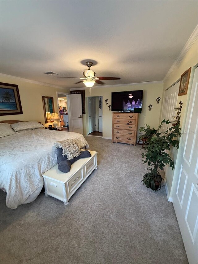bedroom featuring a ceiling fan, visible vents, carpet flooring, and crown molding
