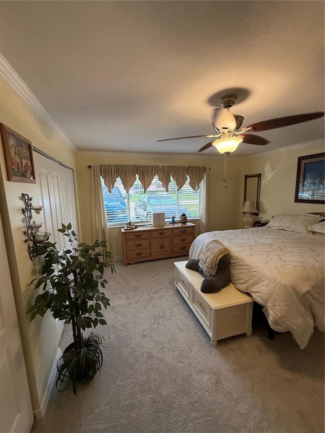 bedroom with ceiling fan, a closet, crown molding, and light carpet