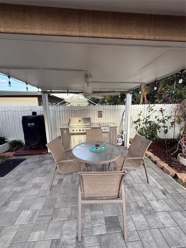 view of patio with outdoor dining area, area for grilling, and fence