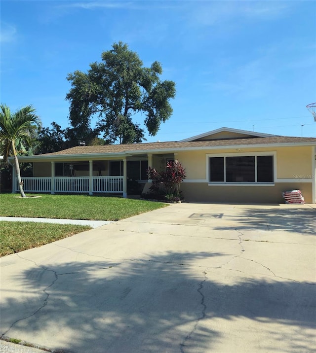 view of front facade with concrete driveway, stucco siding, and a front yard