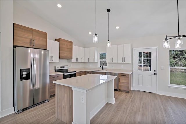 kitchen featuring stainless steel appliances, light countertops, a sink, and a wealth of natural light