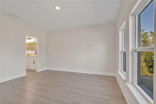 unfurnished room with light wood-type flooring, baseboards, visible vents, and recessed lighting