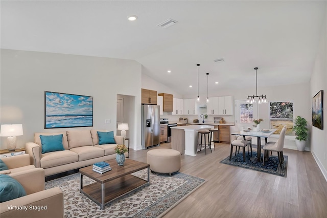 living area with high vaulted ceiling, recessed lighting, visible vents, and light wood-style flooring