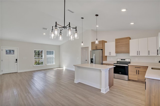 kitchen featuring stainless steel appliances, light countertops, visible vents, a kitchen island, and light wood-type flooring