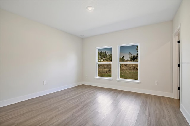 unfurnished room with baseboards and wood finished floors