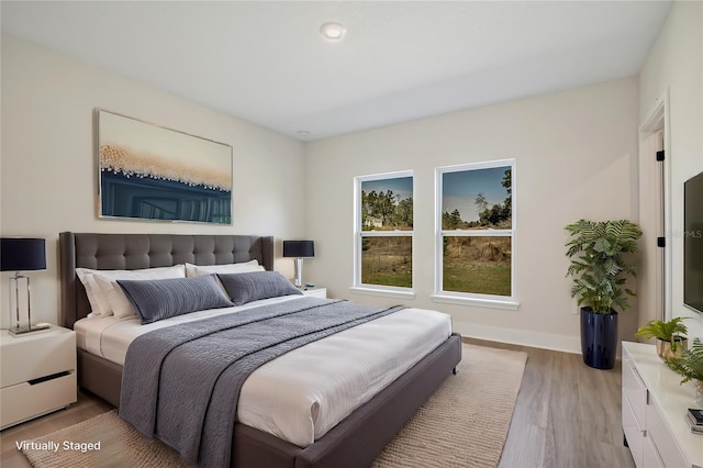 bedroom featuring light wood-type flooring and baseboards