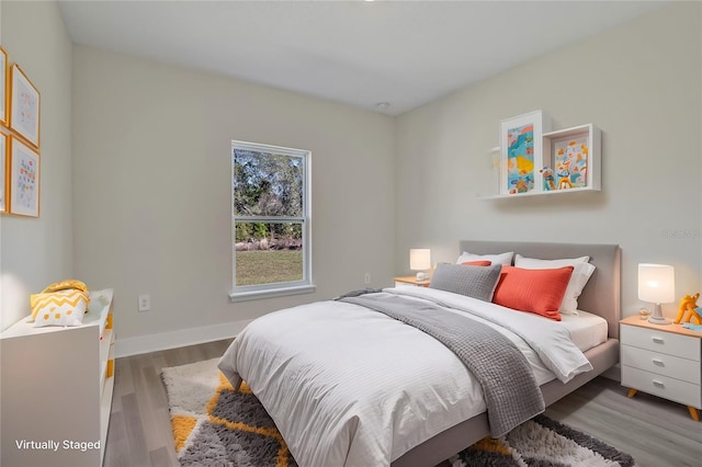 bedroom with baseboards and wood finished floors