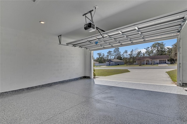 garage featuring a garage door opener and concrete block wall