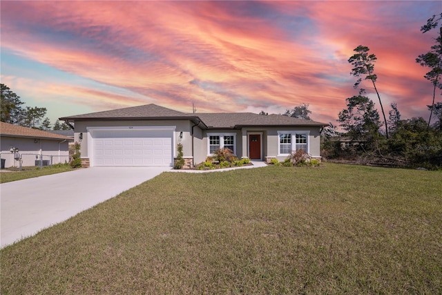 view of front facade with stucco siding, concrete driveway, an attached garage, a front yard, and fence