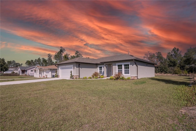 view of front of home featuring a garage, driveway, stone siding, a lawn, and stucco siding