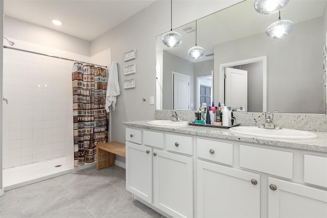 full bathroom with tile patterned flooring, a sink, a tile shower, and double vanity