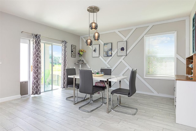 dining space featuring light wood-type flooring and baseboards