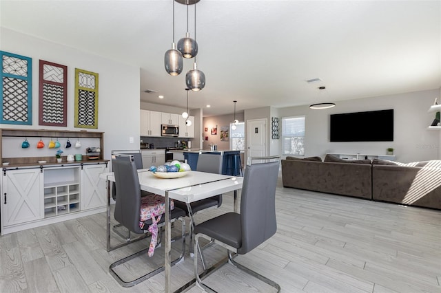 dining room featuring light wood finished floors and recessed lighting