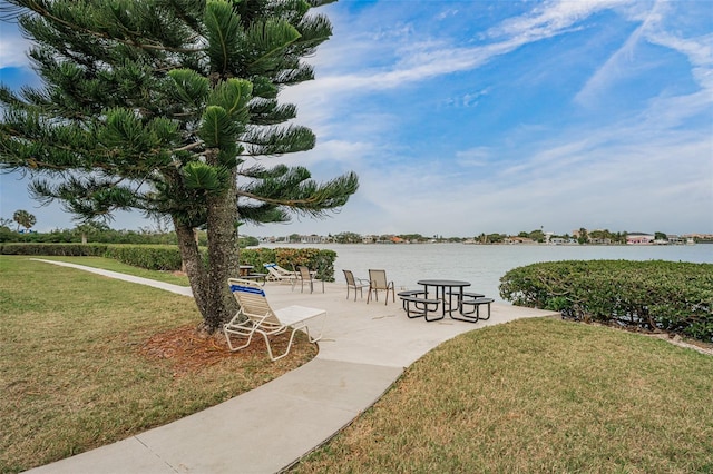 view of home's community with a lawn and a water view
