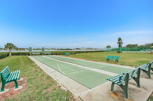 view of property's community featuring a yard and shuffleboard