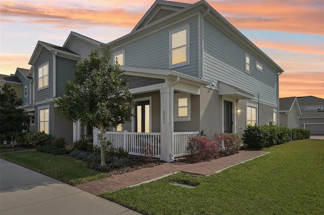 view of front of home with covered porch and a lawn