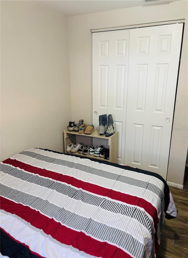 bedroom with a closet and dark wood-type flooring