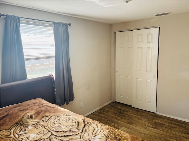 bedroom with a closet and dark hardwood / wood-style floors