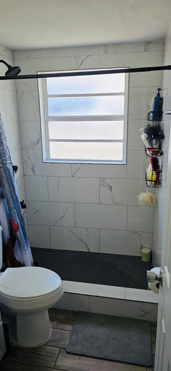 bathroom featuring a shower with shower curtain and toilet