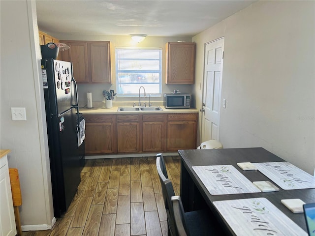 kitchen featuring sink, dark wood-type flooring, and black fridge