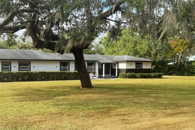 single story home with a front yard and stucco siding