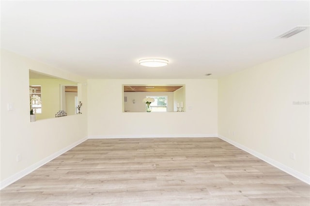 empty room featuring baseboards, visible vents, and light wood-style floors