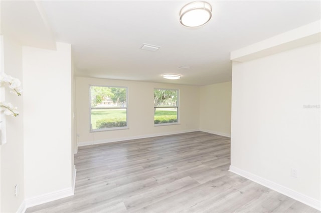 unfurnished room with light wood finished floors and baseboards