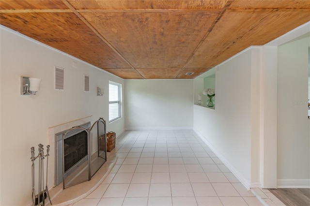 unfurnished living room with light tile patterned floors, visible vents, wood ceiling, baseboards, and a tiled fireplace