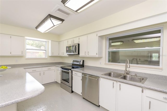 kitchen with visible vents, white cabinets, appliances with stainless steel finishes, light countertops, and a sink