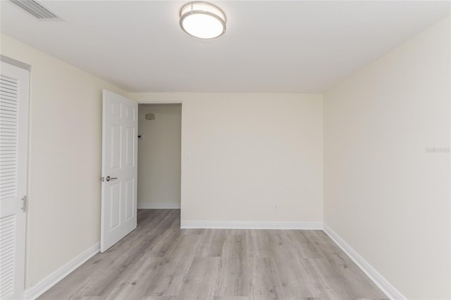 spare room featuring baseboards, visible vents, and light wood-style flooring