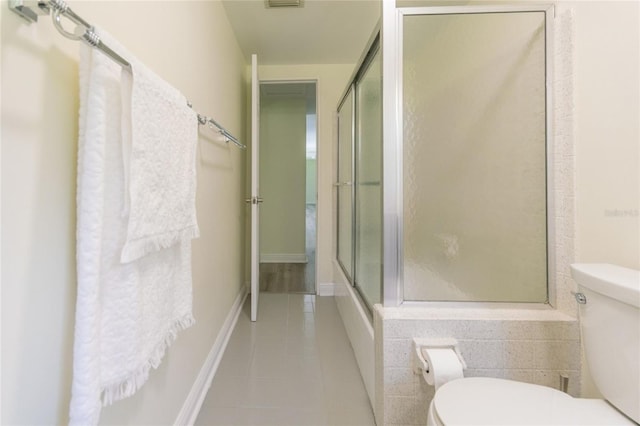 bathroom featuring tile patterned floors, baseboards, toilet, and an enclosed shower